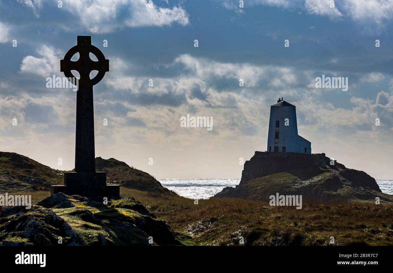 La croce celtica e il faro di Twr Mawr sull'isola di Llanddwyn, Anglesey Foto Stock