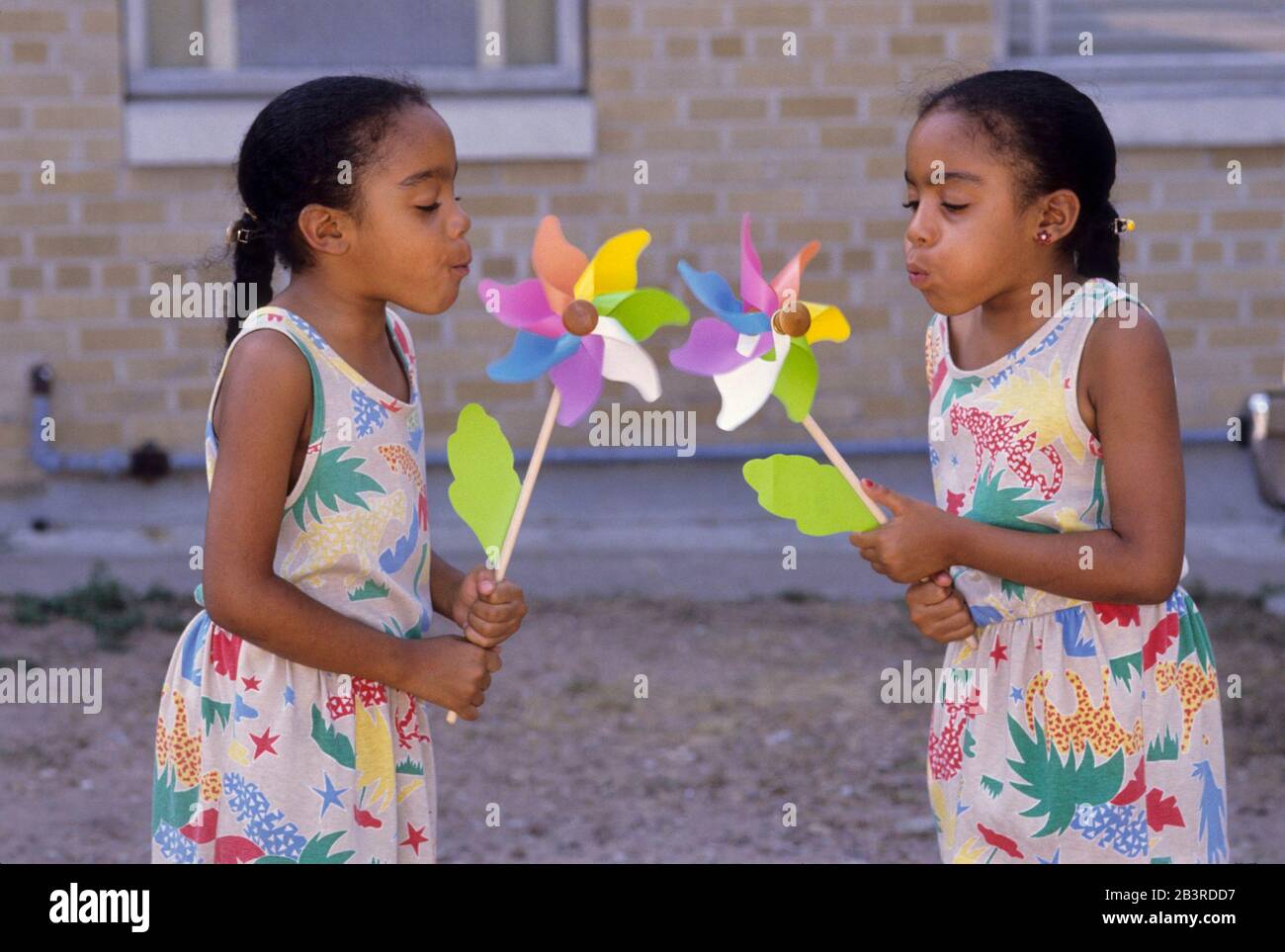 Austin Texas USA, circa 1993: Le sorelle gemelle nere di otto anni soffiano sui volani per farli girare .©Bob Daemmrich Foto Stock