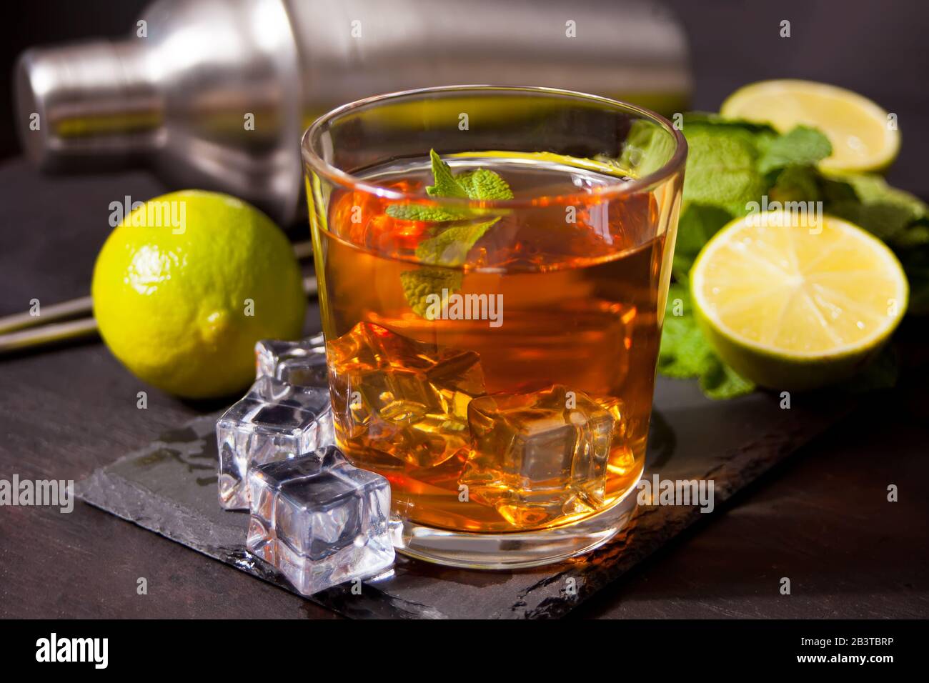 Cocktail fresco Cuba Libre o cocktail whiskey cola con rum marrone, cola, menta e lime su sfondo nero. Long Island Iced Tea Cocktail. Foto Stock
