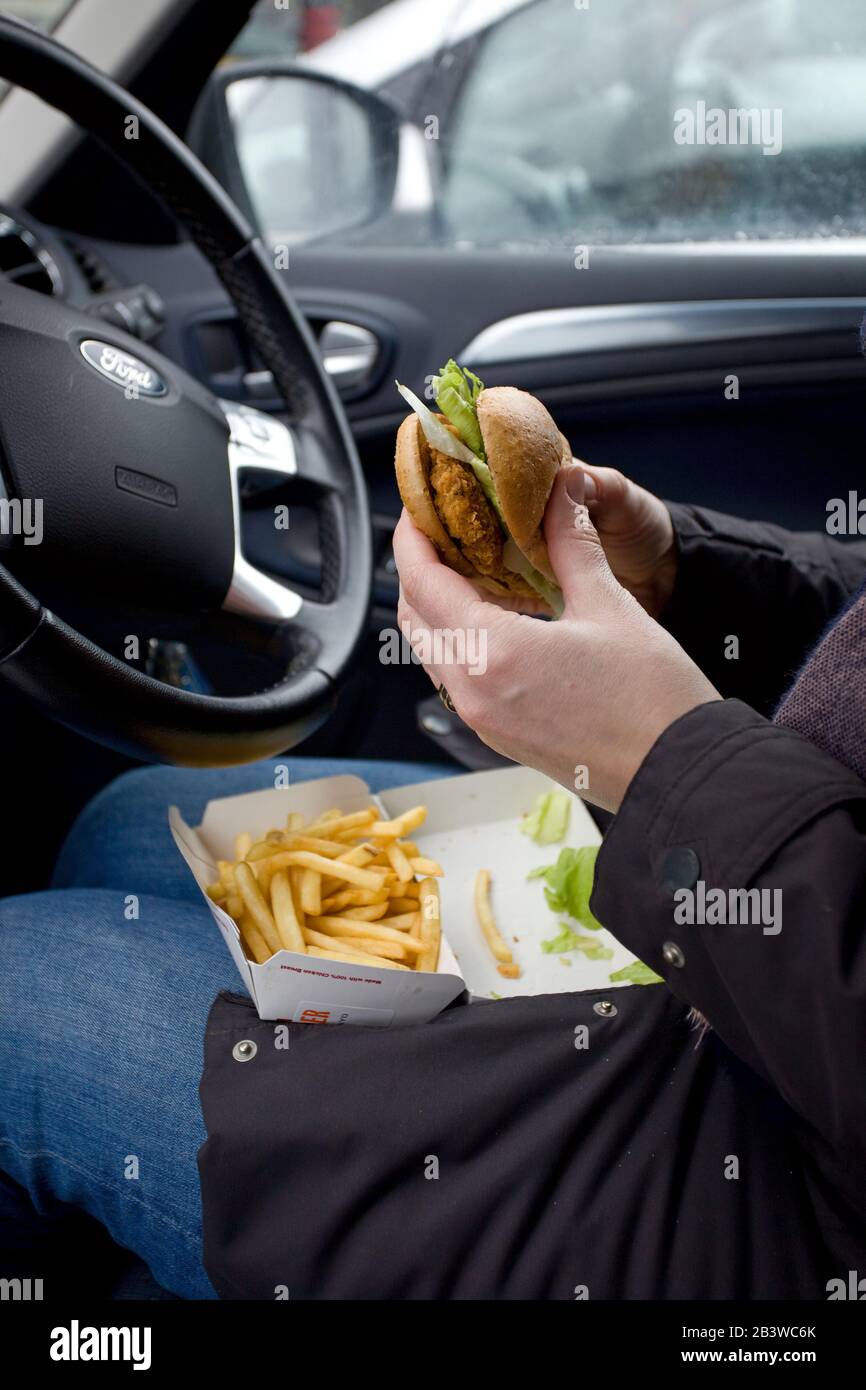 Mangiare hamburger di pollo McDonalds e patatine fritte in auto, regno unito Foto Stock
