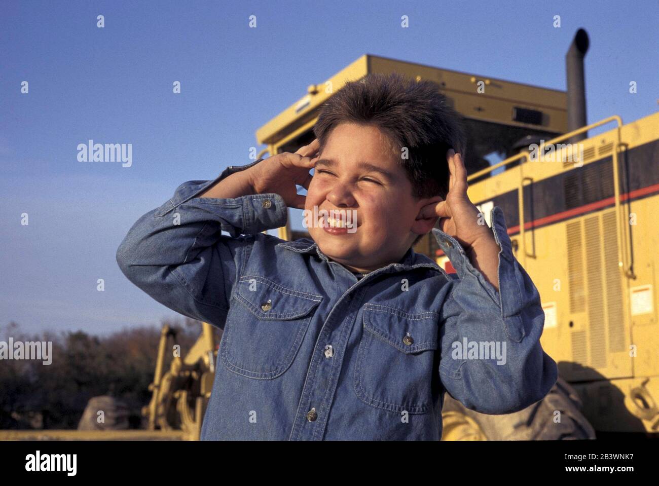 Austin Texas USA: Il bambino mette le dita nelle orecchie con le mani per soffocare il rumore forte della costruzione. SIGNOR ©Bob Daemmrich Foto Stock