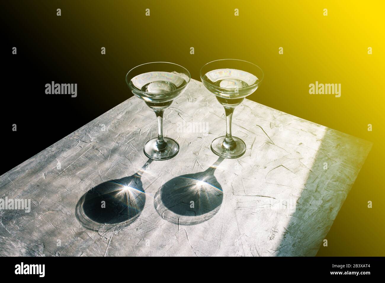 Bevande alcoliche. Due bicchieri di vetro con un cocktail. Luce solare portare un bicchiere d'acqua Foto Stock