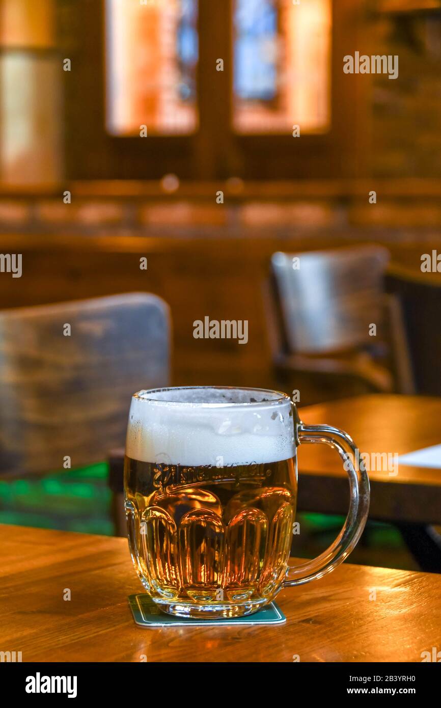 Praga, REPUBBLICA CECA - LUGLIO 2018: Bicchiere di birra alla spina ceca in schiuma su un tavolo di legno in un bar a Praga Foto Stock
