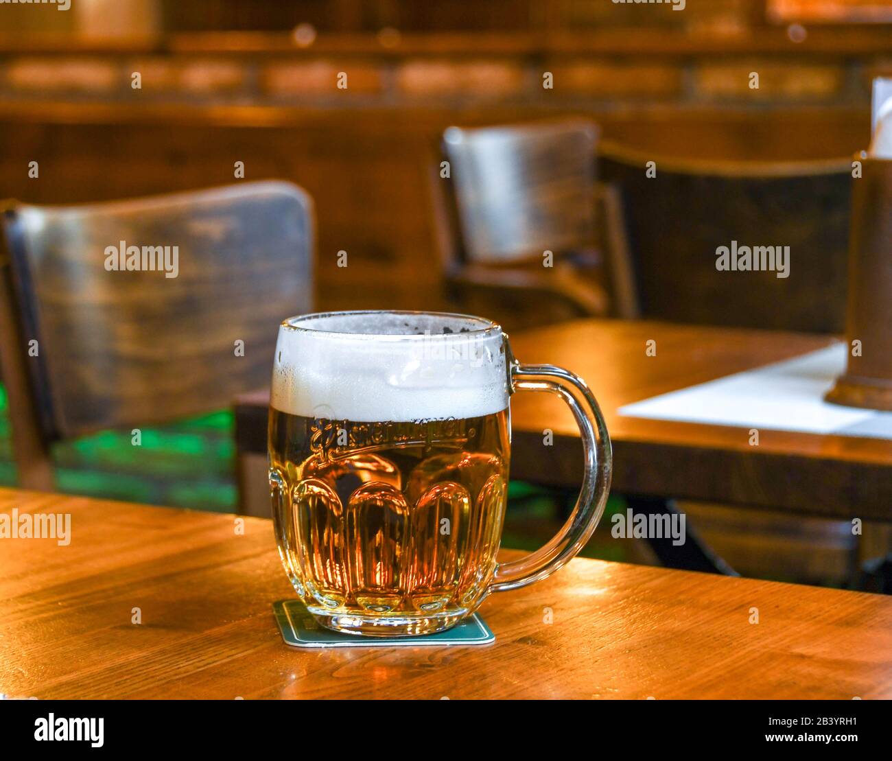 Praga, REPUBBLICA CECA - LUGLIO 2018: Bicchiere di birra alla spina ceca in schiuma su un tavolo di legno in un bar a Praga Foto Stock