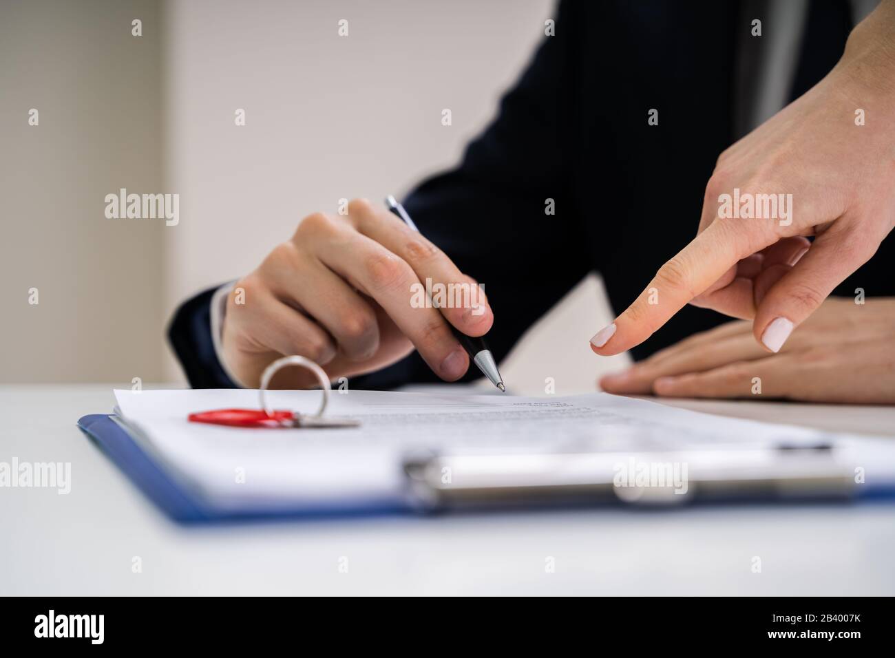 Close-up di mano di una persona firma un contratto con tasti Foto Stock