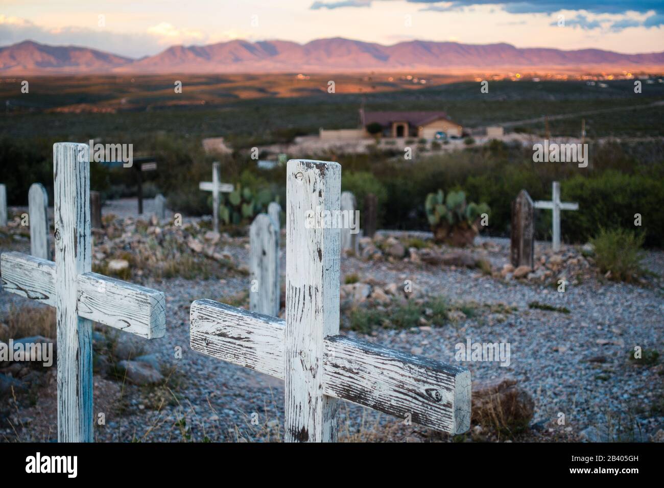 Due marcatori di croce in legno che si affacciano sulle colline nel famoso cimitero di Boothill a Tombstone, Arizona. Tramonto in lontananza, nessuna gente visibile. Foto Stock