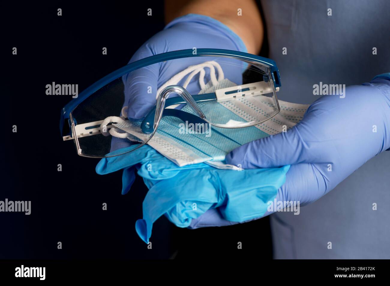 L'infermiere offre dispositivi di protezione personale, guanti, maschere e occhiali di sicurezza. Foto Stock