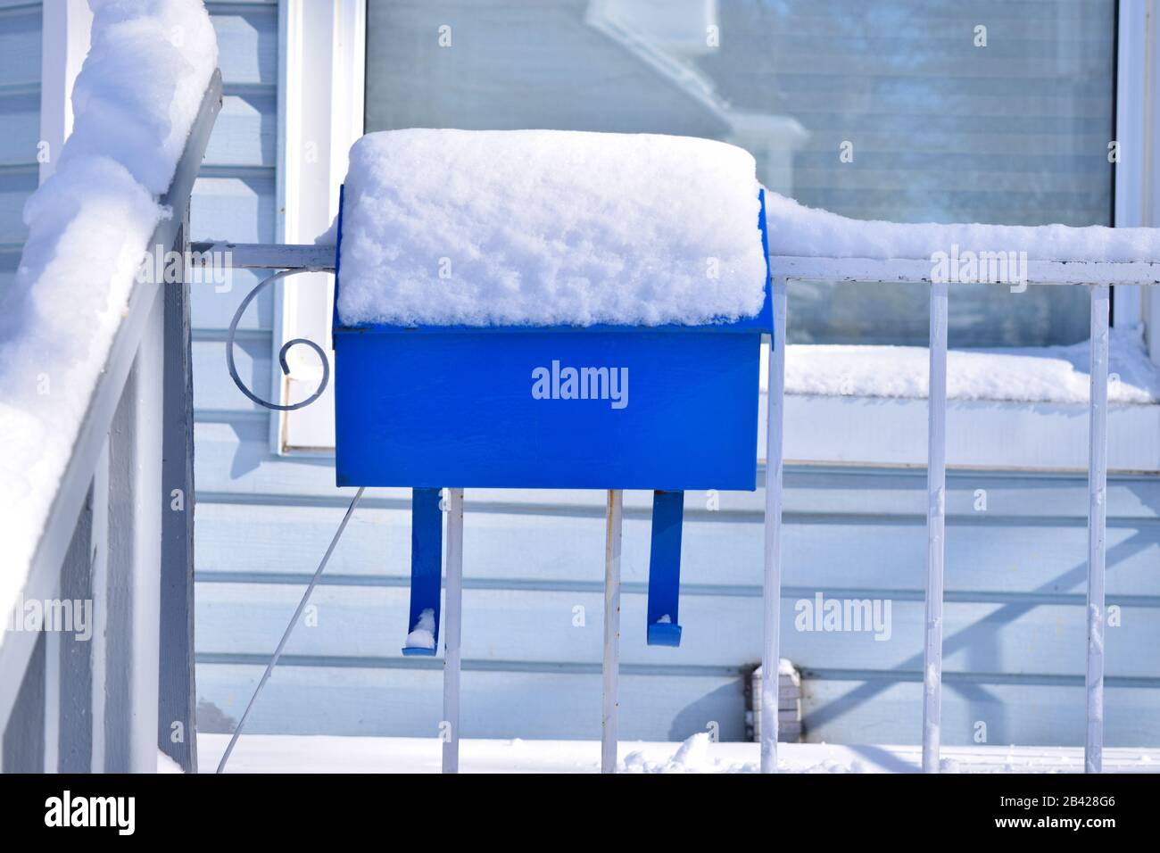 Casella postale blu coperta di neve su un portico. Pomeriggio del giorno della neve. Il servizio postale non funziona durante il blocco Foto Stock