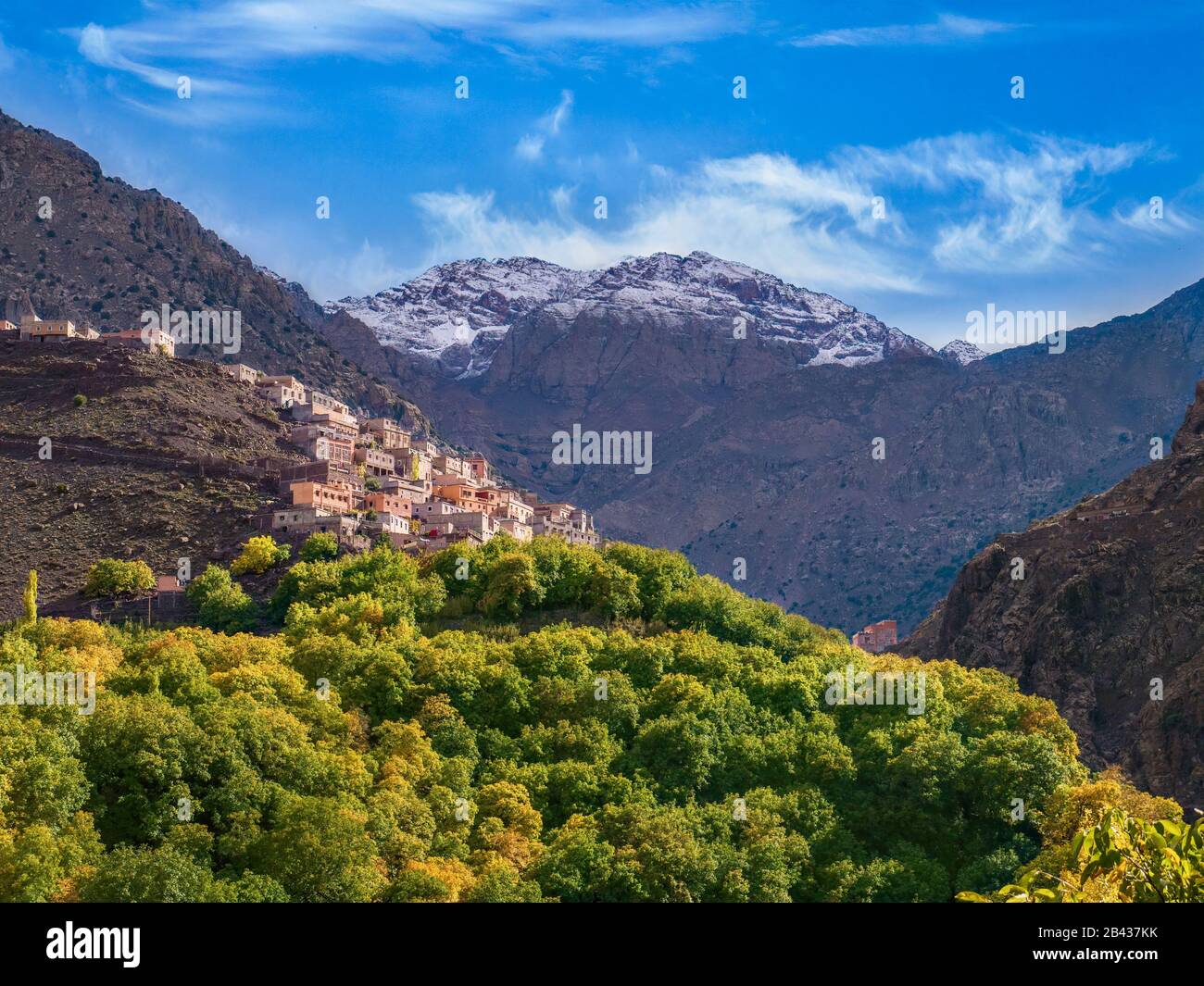 Il villaggio berbero di Aroumd, sulle montagne dell'alto Atlante del Marocco, con le cime innevate del Jbel Toubkal, la montagna più alta del Nord Africa sul retro. Foto Stock