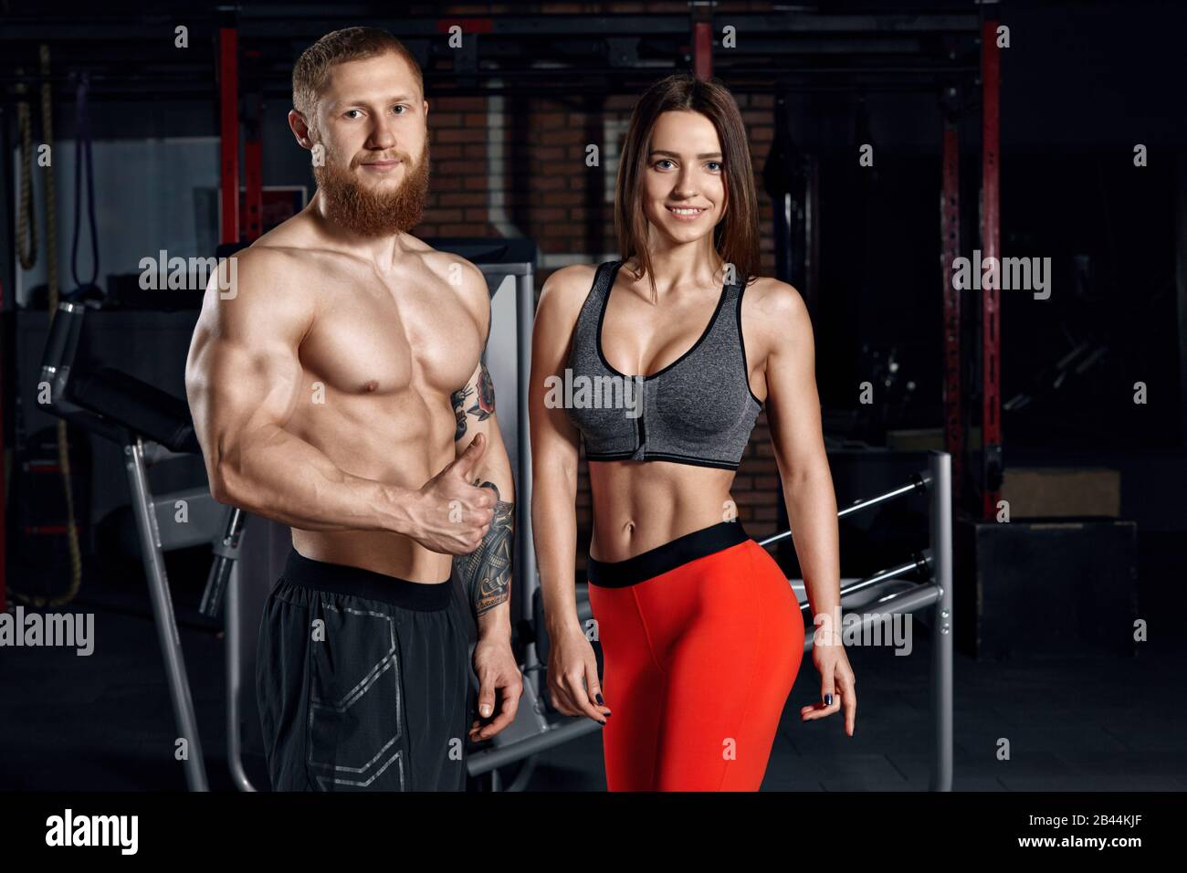 Ritratto di una giovane coppia sportiva in palestra. Contesto di concetto di idoneità. Foto Stock