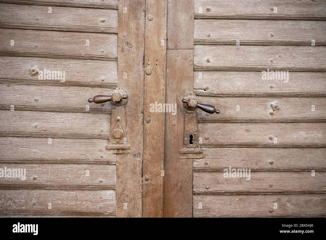 chiudete la vecchia porta decorata in legno vintage con una maniglia della porta in ferro. Foto Stock