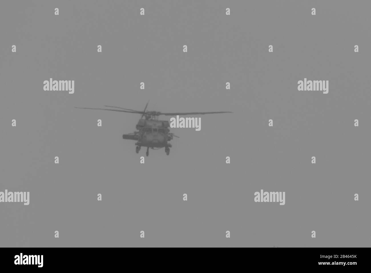 Il chopper militare si abbassa nel combattimento e la guerra volando nel fumo e nel caos e nella distruzione. Concetto militare di potere, forza, forza, aria raid. Foto Stock