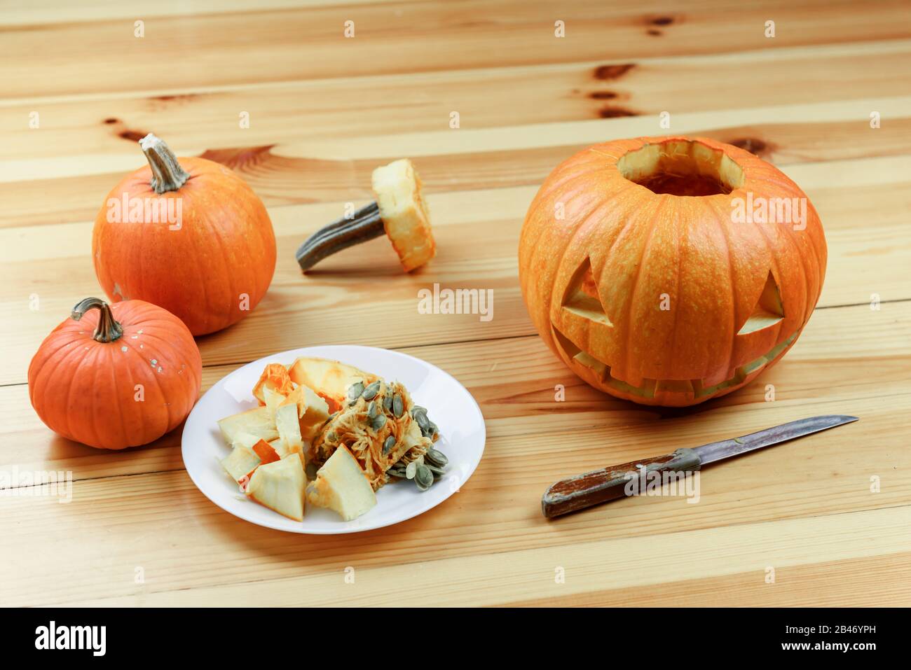 Scultura di Halloween. Primo piano di zucche o jack-o-lantern e coltello a casa. Decorazione e concetto di vacanza Foto Stock