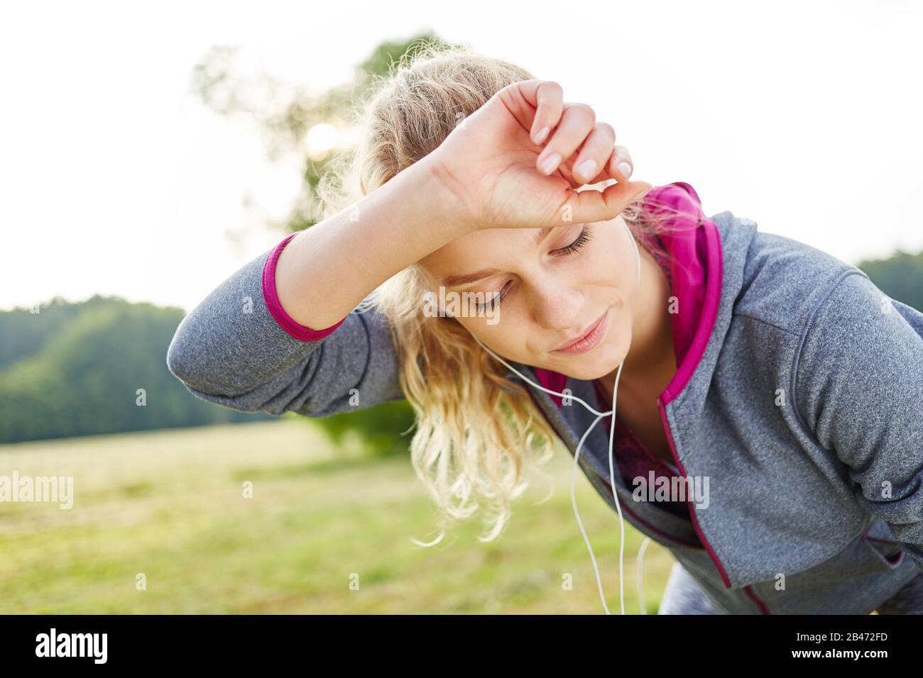 Donna esausta pulisce il sudore dalla fronte mentre parava Foto Stock