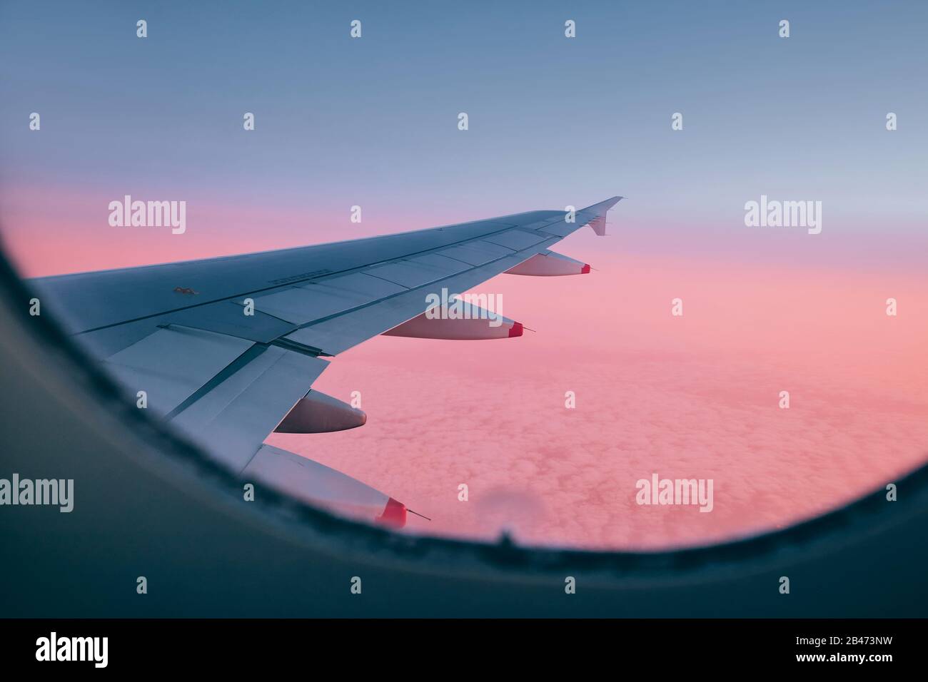 Vista dalla finestra aereo. Ala durante il volo sopra le nuvole al bel tramonto. Foto Stock
