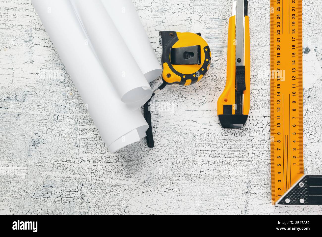 Gli schemi architetturali e blueprint rotoli e a strumenti di disegno sul piano di lavoro. Foto Stock
