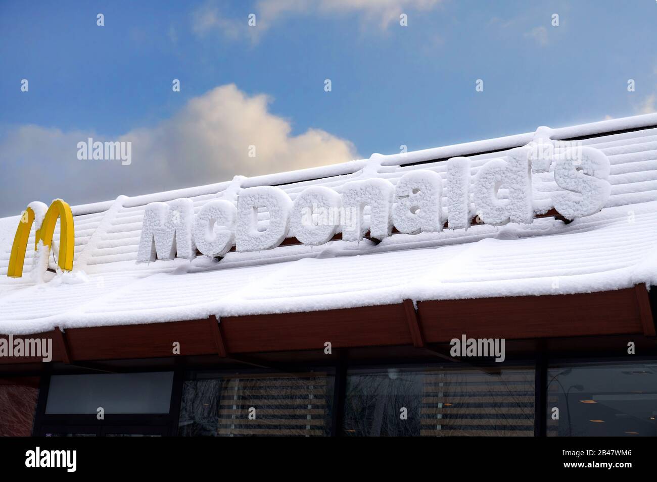 Logo aziendale coperto da una copertura per la neve. Fast food McDonald's. Questa Corporation è un'azienda americana di fast food. Foto Stock