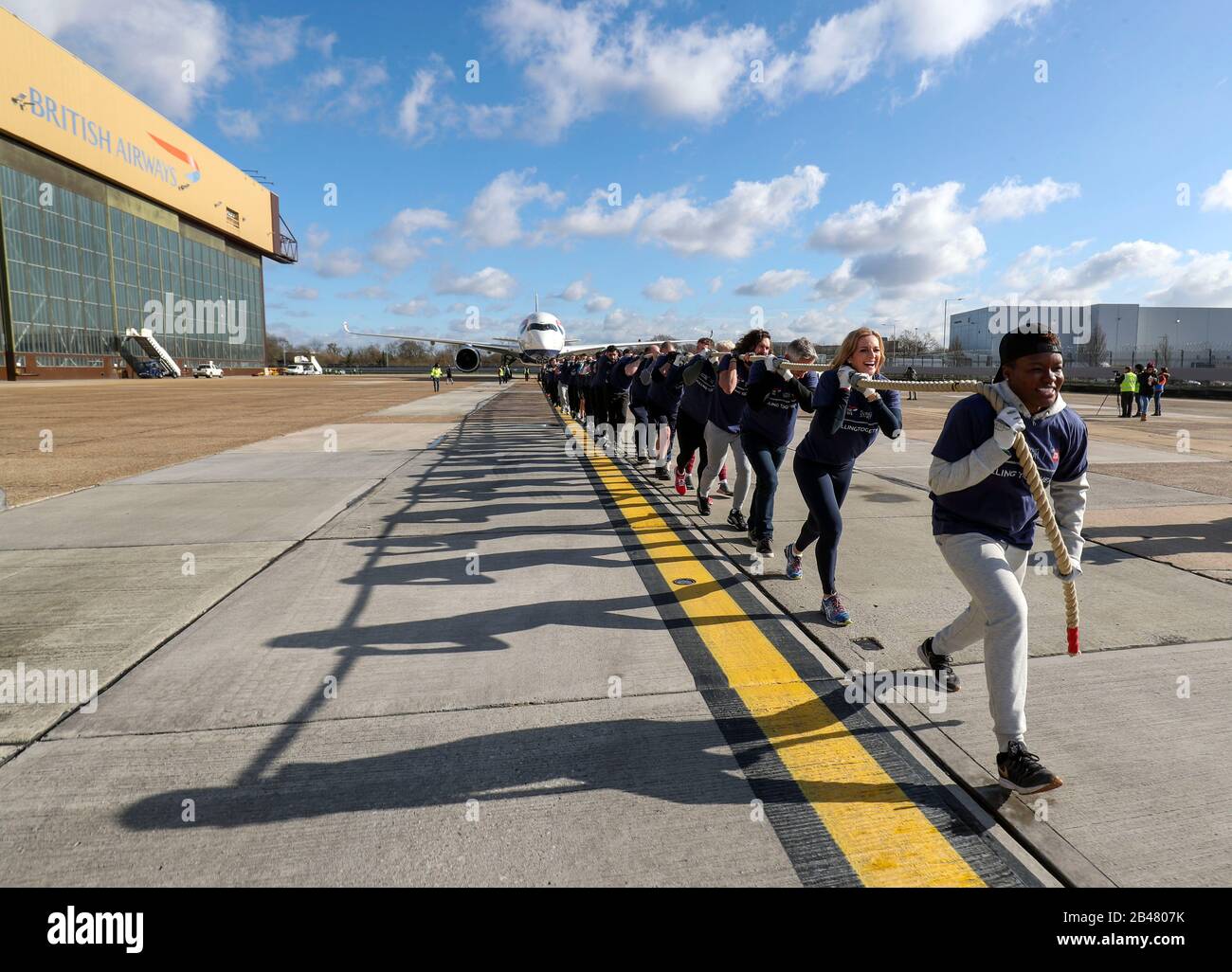 (Da davanti a dietro) Nicola Adams, Gabby Logan, Garry Lineker, Joe Wicks, Iwan Thomas e Alfie Hewett si uniscono ai membri del personale nel tentativo di rompere il Guinness World Record per il più pesante 100m A350 aereo tira durante un evento di soccorso sportivo all'aeroporto di Heathrow a Londra. Foto Stock