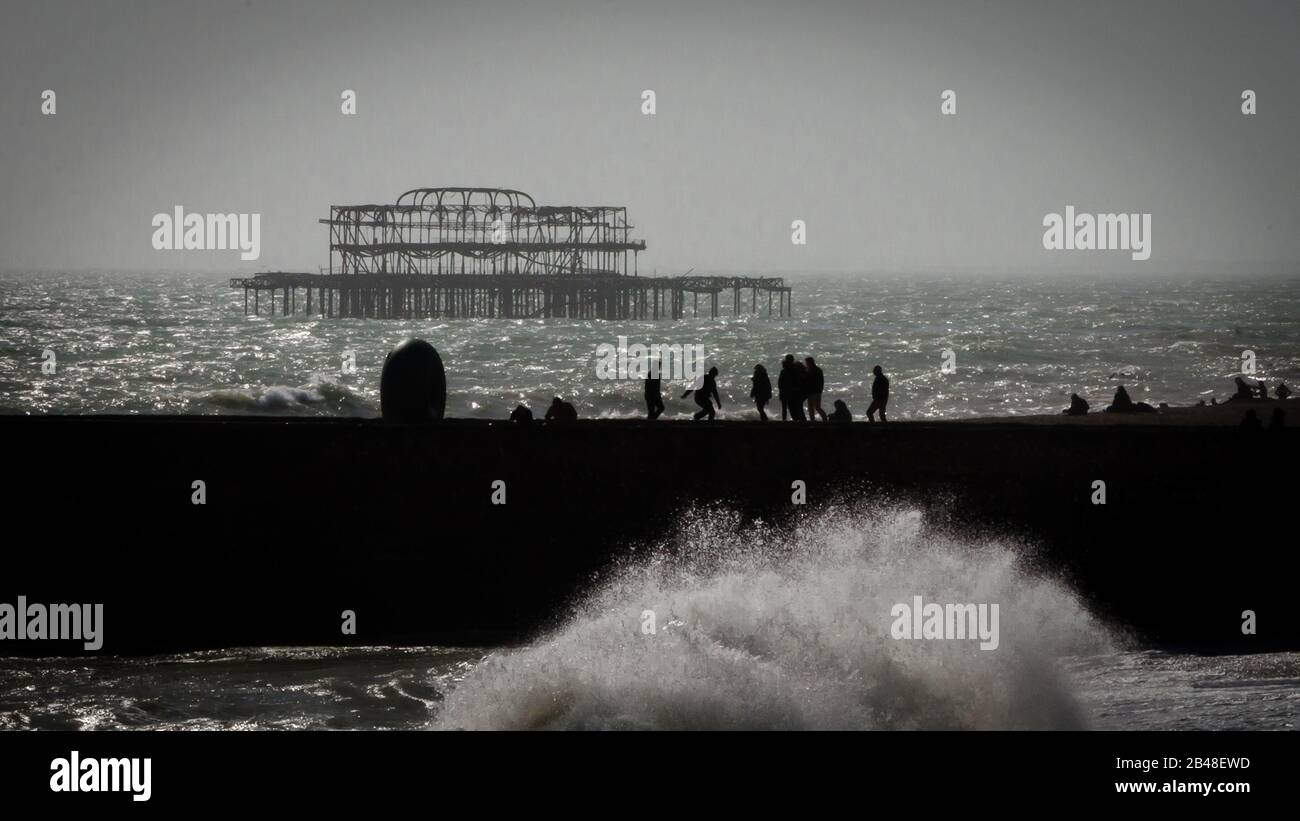 Il vecchio West Pier di Brighton, Inghilterra, Regno Unito, con la silhouette di ciambella groyne e le onde che si infrangono Foto Stock