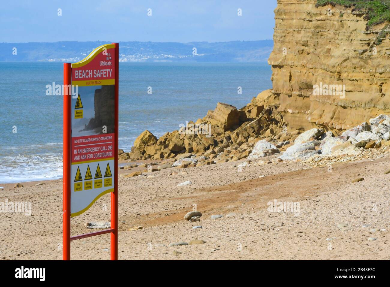 Hive Beach, Burton Bradstock, Dorset, Regno Unito. 6th marzo 2020. Meteo Regno Unito. Sole oggi dove una parte di scogliera a Hive Beach a Burton Bradstock a Dorset è crollato ieri dopo mesi di pioggia pesante e tempeste ha colpito la costa. La parte di scogliera tra Burton Bradstock e West Bay ha avuto frequenti cadute di roccia nel corso del mese scorso ed è molto instabile. Nella foto è raffigurato uno dei segnali di sicurezza della spiaggia con la scogliera che cade dietro. Foto Di Credito: Graham Hunt/Alamy Live News Foto Stock