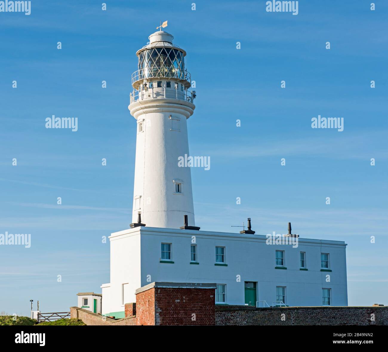 Grande faro bianco con torre faro sulla costa Foto Stock