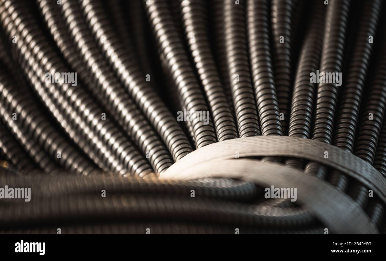 Primo piano di un enorme gruppo di tubi flessibili in metallo interconnessi in una fabbrica o in un impianto. Il concetto di moderna tecnologia elettronica E IT. Copyspace Foto Stock