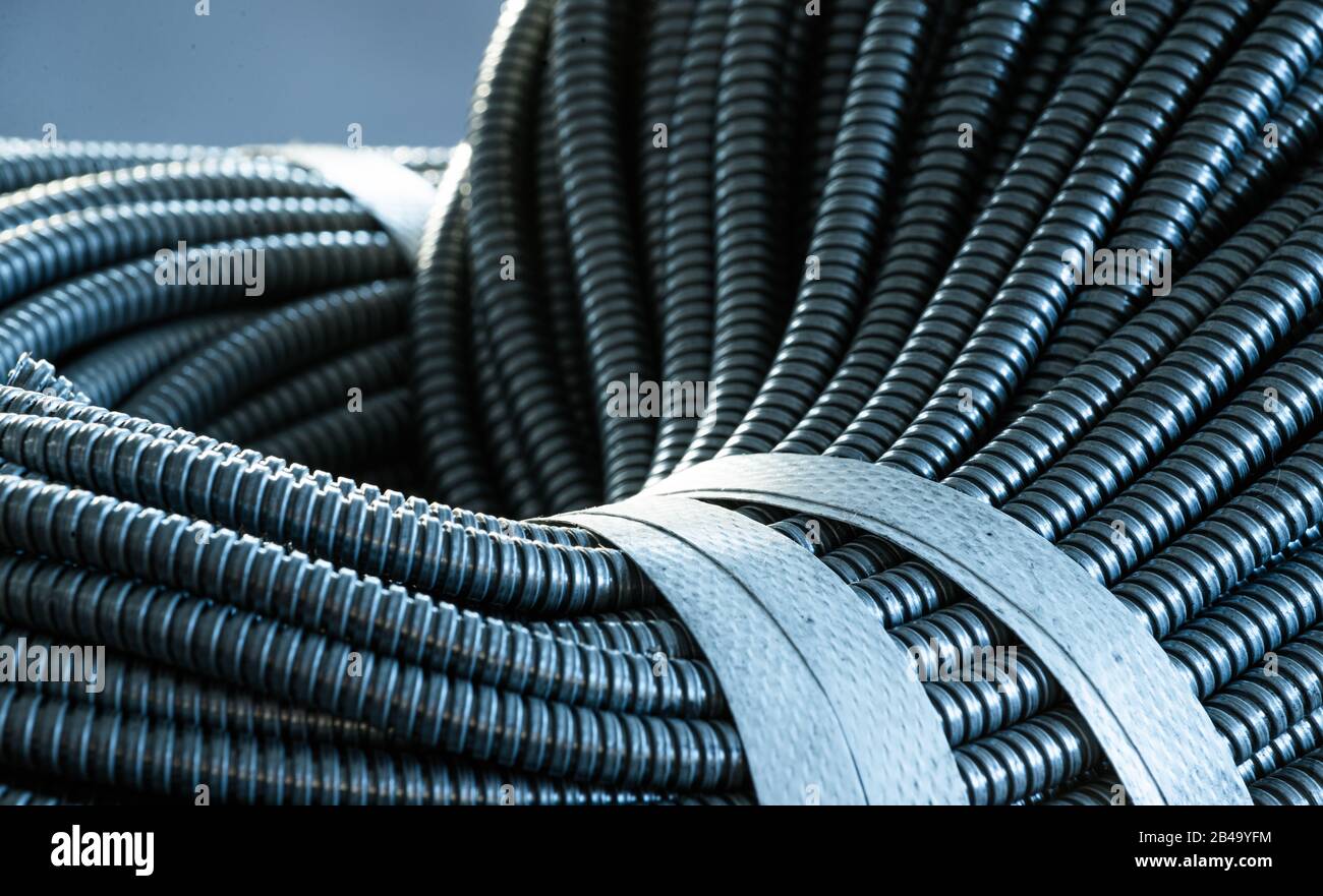 Primo piano di un enorme gruppo di tubi flessibili in metallo interconnessi in una fabbrica o in un impianto. Il concetto di moderna tecnologia elettronica E IT. Copyspace Foto Stock