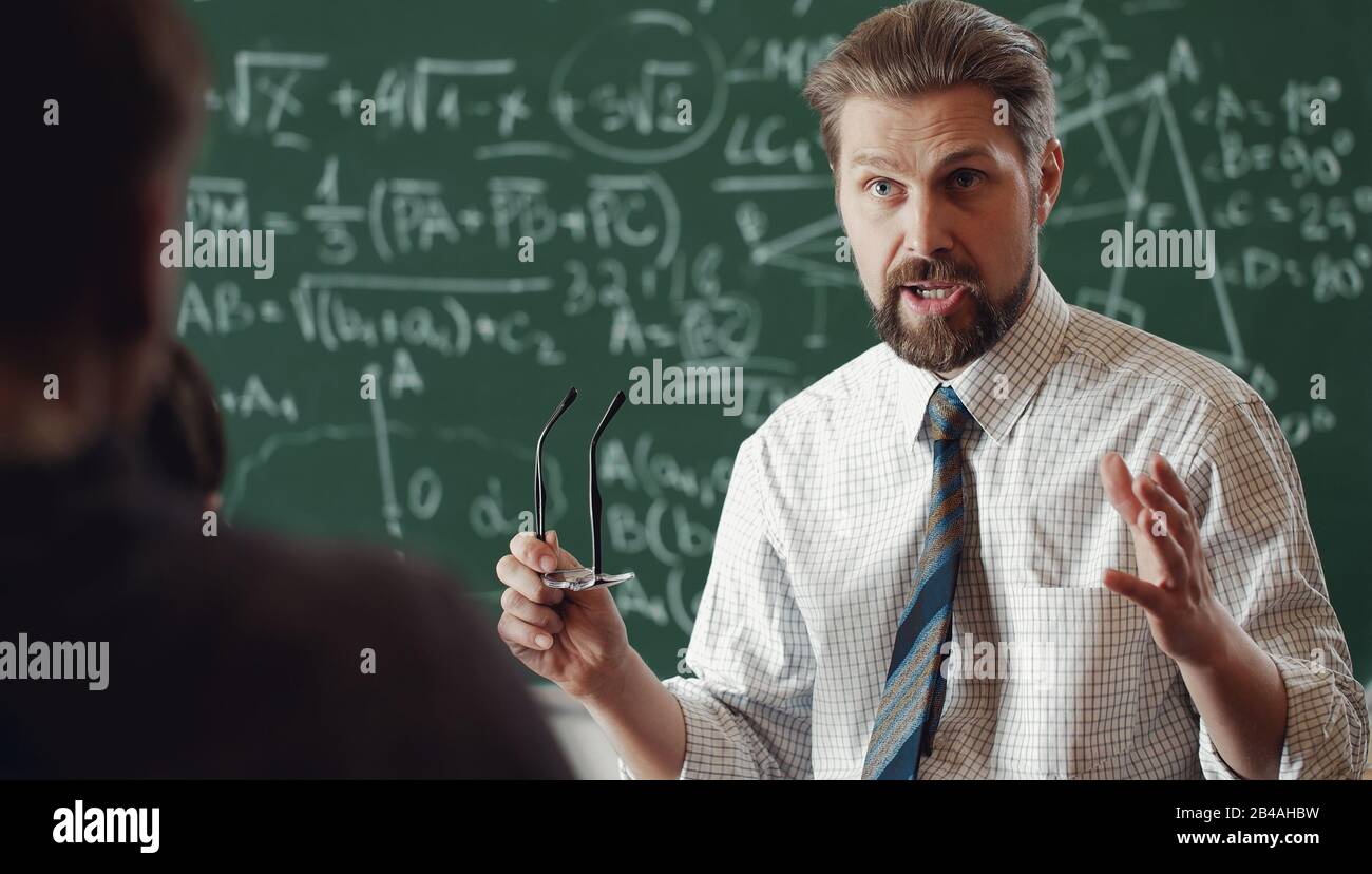 Insegnante vivace che spiega il tema della matematica Foto Stock