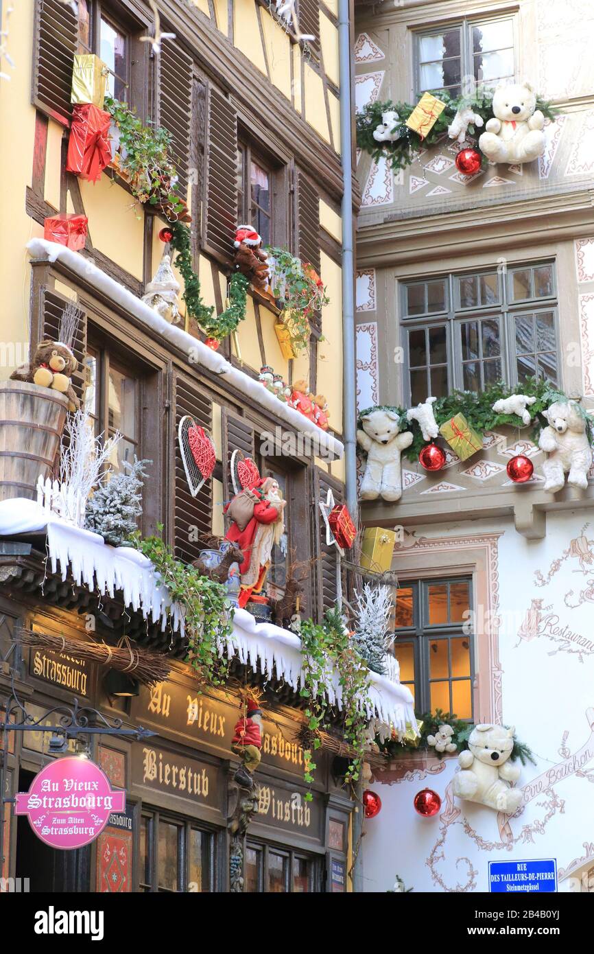 Francia, Bas Rhin, Strasburgo, rue des tailleurs de pierre, facciata dei winstubs Au Vieux Strasbourg e le Tire Bouchon (sullo sfondo) con le loro decorazioni durante il mercato di Natale (Christkindelsmärik) Foto Stock