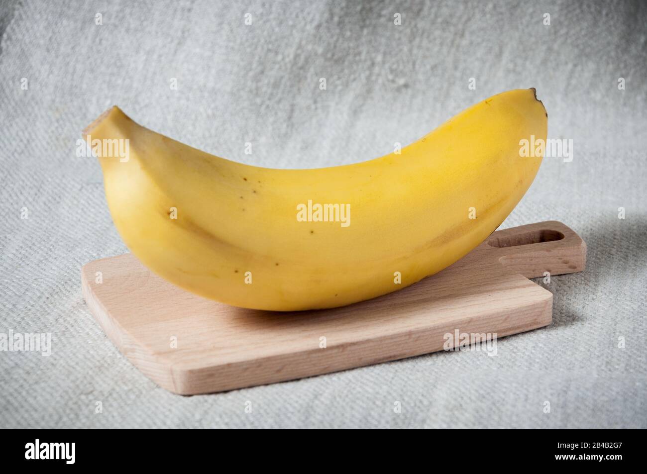 Frutta tropicale fresca su una tavola di legno. Banana fresca gialla. Ingrediente di cottura Foto Stock