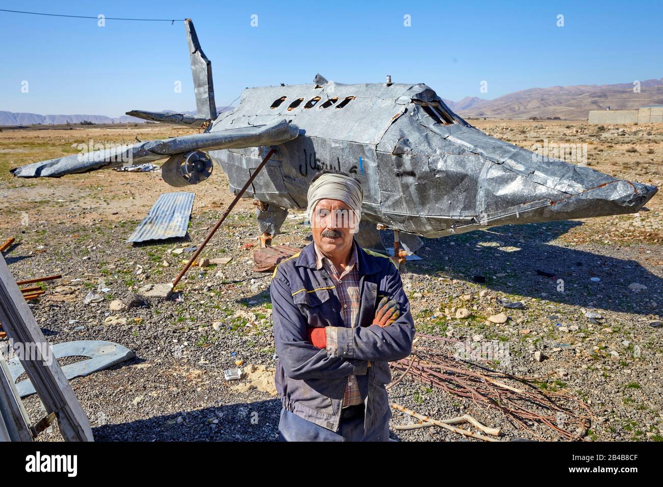Un commerciante di rottami si trova di fronte a un modello di aeroplano auto-fatto vicino alla città iraniana di Firuzabad, presa il 04.12.2017. | utilizzo in tutto il mondo Foto Stock