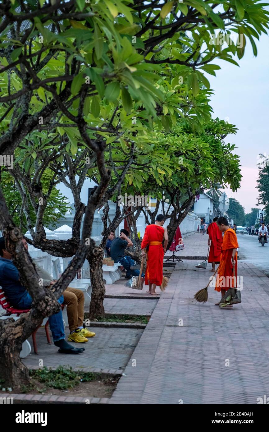 Laos, Luang Prabang, dichiarata Patrimonio dell'Umanità dall'UNESCO, monaci che si trovano di fronte al Palazzo reale all'alba Foto Stock