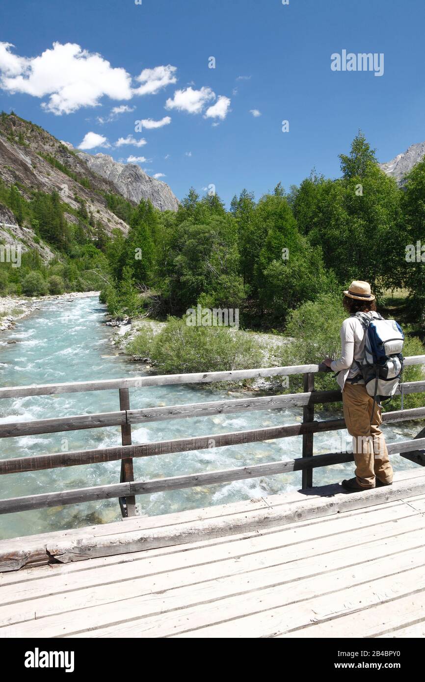 Francia, Alpes de Haute Provence, Ubaye, Saint Paul sur Ubaye, escursionista femminile su un ponte sul fiume Ubaye Foto Stock