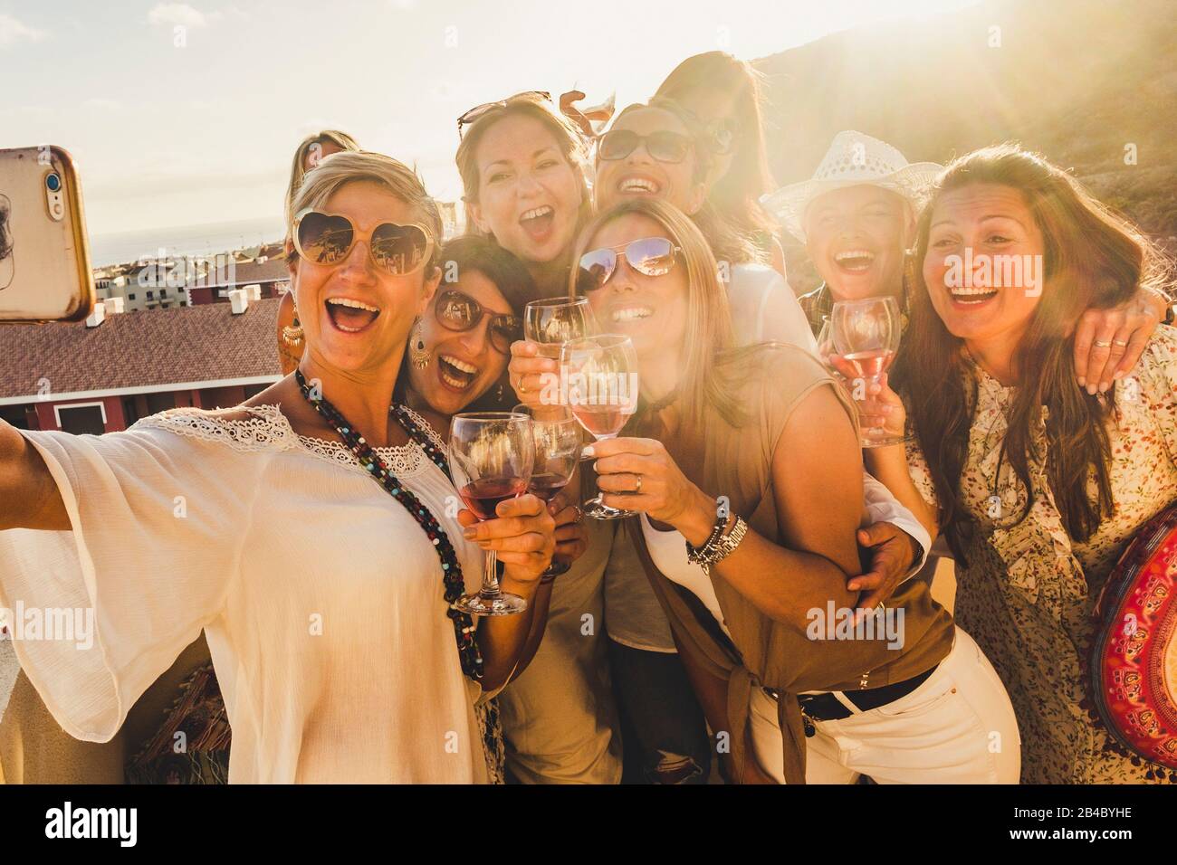 Concetto di felicità per le giovani donne caucasiche amici ridere e divertirsi insieme in amicizia prendere un selfie foto con uno smartphone - sole in retroilluminazione e vista Foto Stock