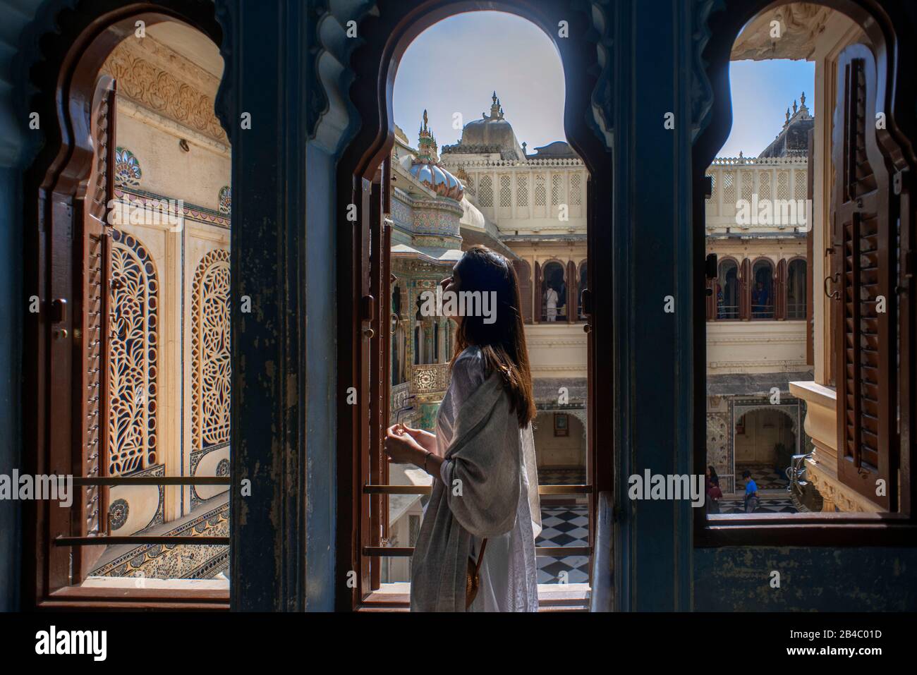 Donna silhouette sul balcone in Udaipur City Palace museo a Udaipur, Rajasthan, India. Questa è una delle escursioni del treno di lusso Maharaja Foto Stock