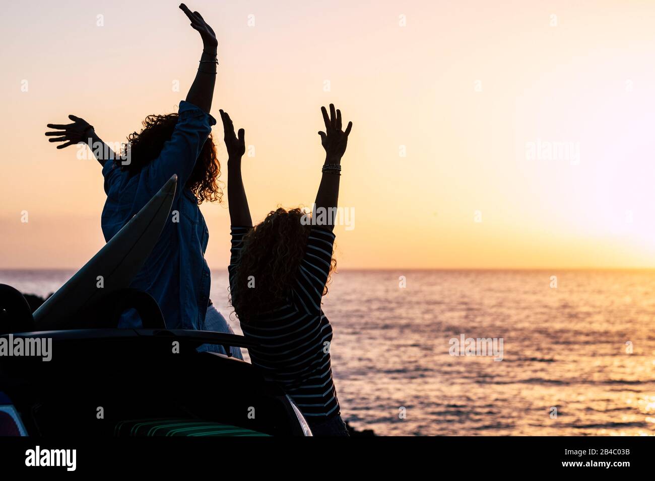 Felicità e concetto di successo con coppie di giovani amici godere il tramonto in vacanza vacanza estate - gioioso e persone in viaggio all'aperto attività di svago - oceano e sfondo del sole Foto Stock