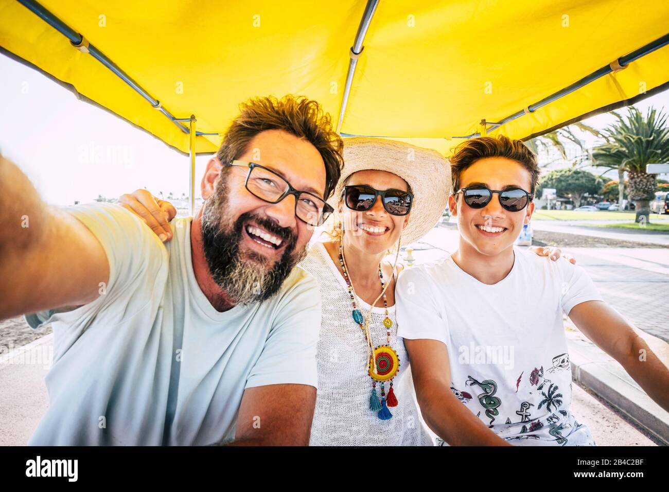 Concetto di famiglia di gente felice - figlio di madre e padre ridere molto e divertirsi insieme nell'attività di svago all'aperto - gruppo caucasico di amici di età e generazioni diverse Foto Stock