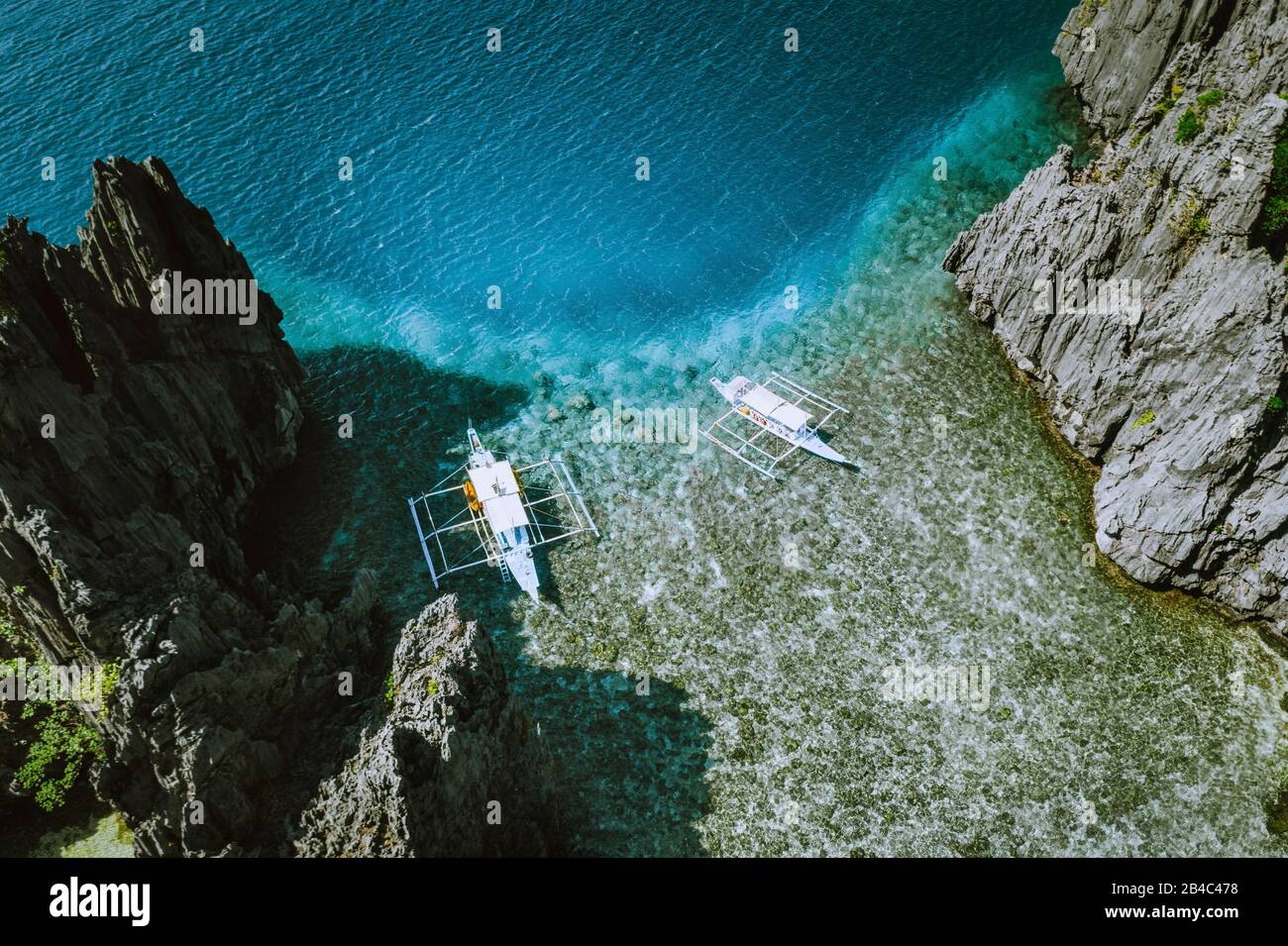 Foto aerea delle isole Filippine a Palawan. Banca barche al mattino poco profondo acqua in ordine alle rocce. Foto Stock