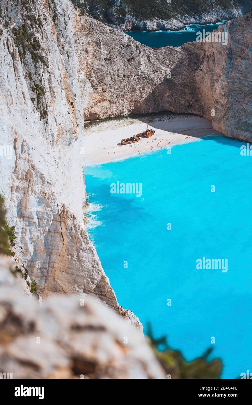 Gesso calcare dorato come grande rupe di rocce che circonda Navagio beach con naufragio e azzurro acqua di mare. L'isola di Zante, Grecia. Foto Stock