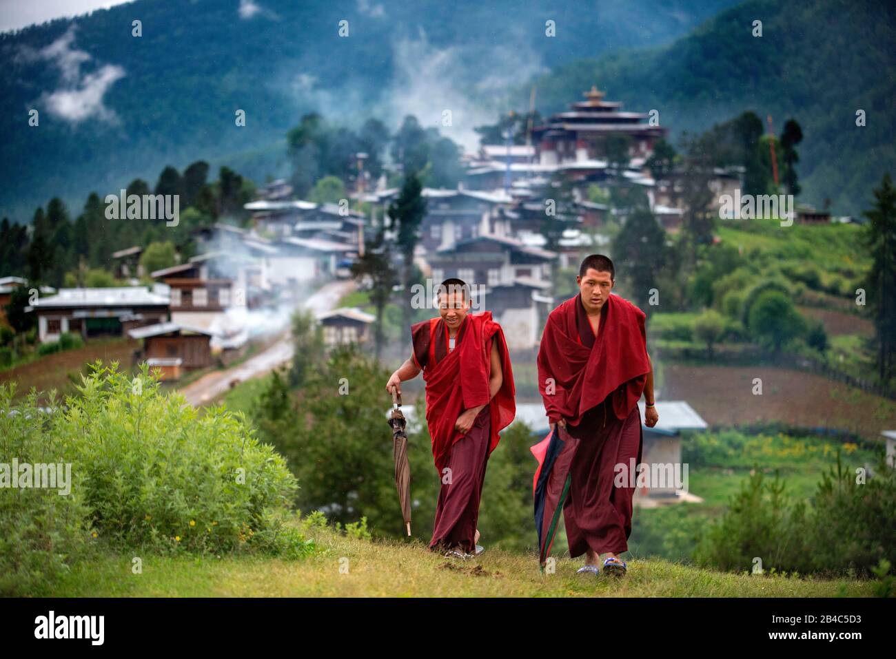Monaci che lasciano il monastero di Gangtey Dzong Gangten villaggio Phobjikha Valle Bhutan. Il Monastero di Gangteng, conosciuto generalmente come Gangtey Gonpa o Gangtey Mona Foto Stock
