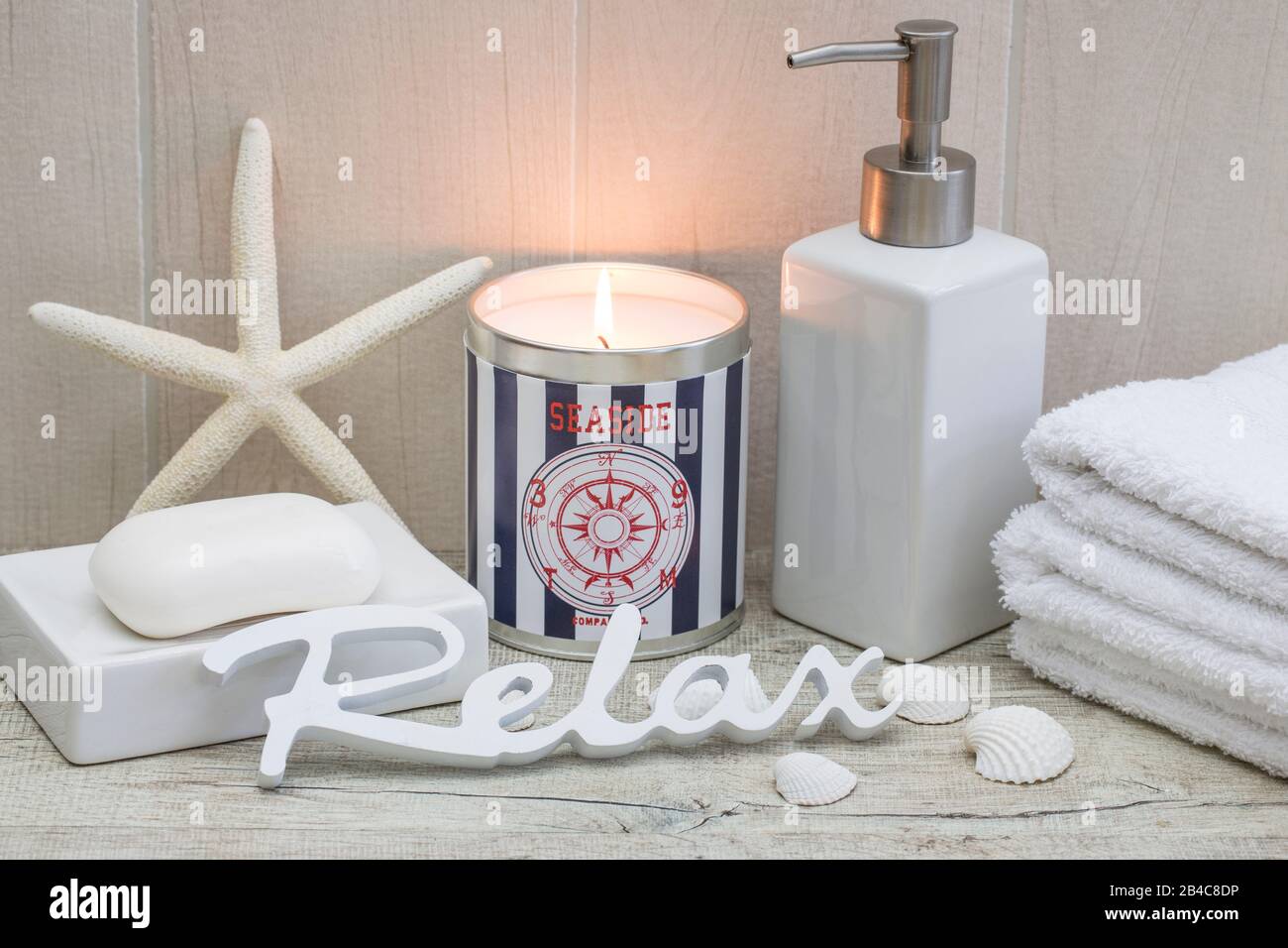 maritime spa ancora vita con candela nautica, sapone, asciugamani conchiglie e parola relax Foto Stock