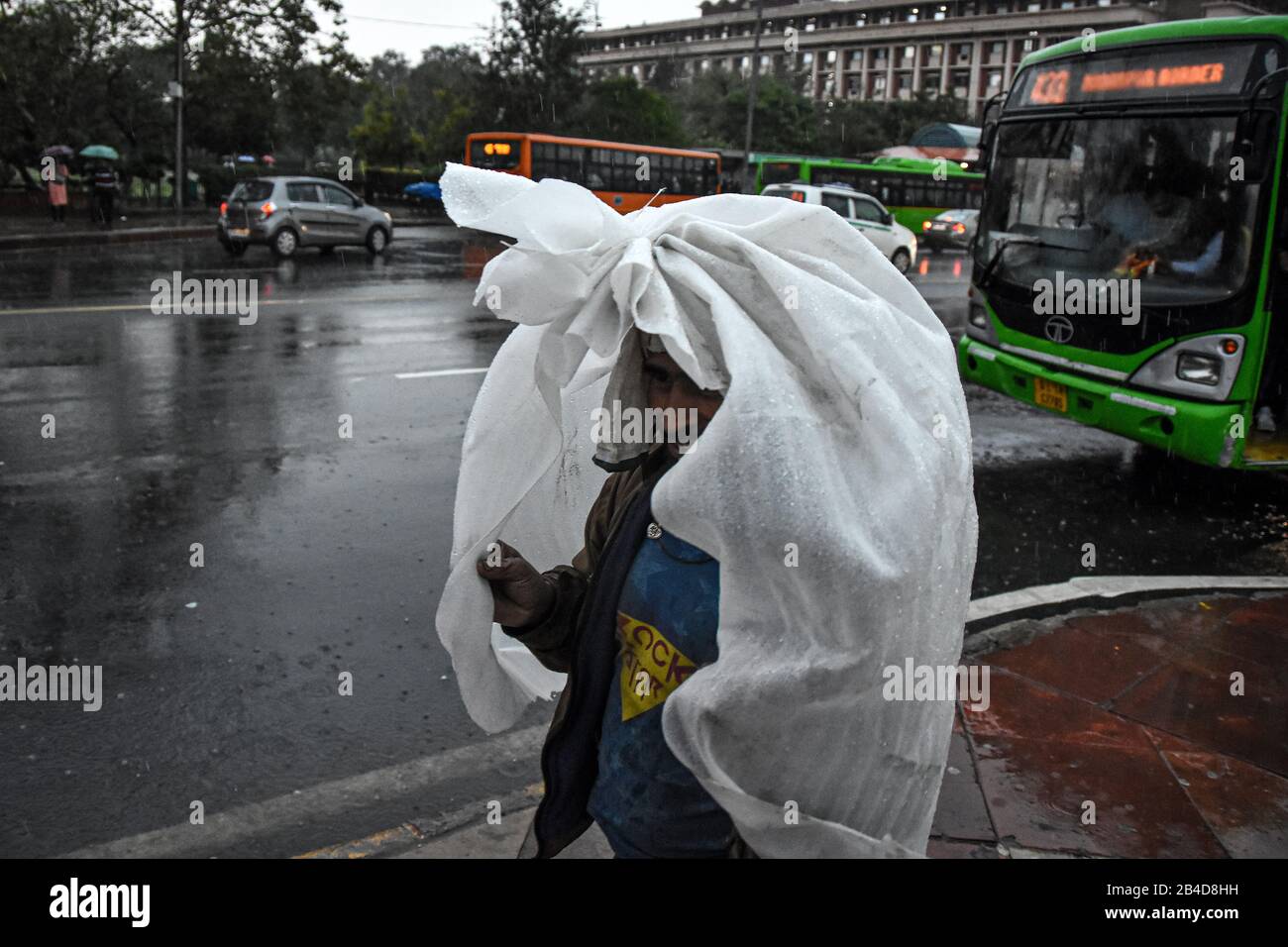 Delhi, India. 06th Mar, 2020. Una persona che usa un sacchetto di plastica come scudo contro la pioggia durante un monsone pesante downpour. Credit: Sopa Images Limited/Alamy Live News Foto Stock