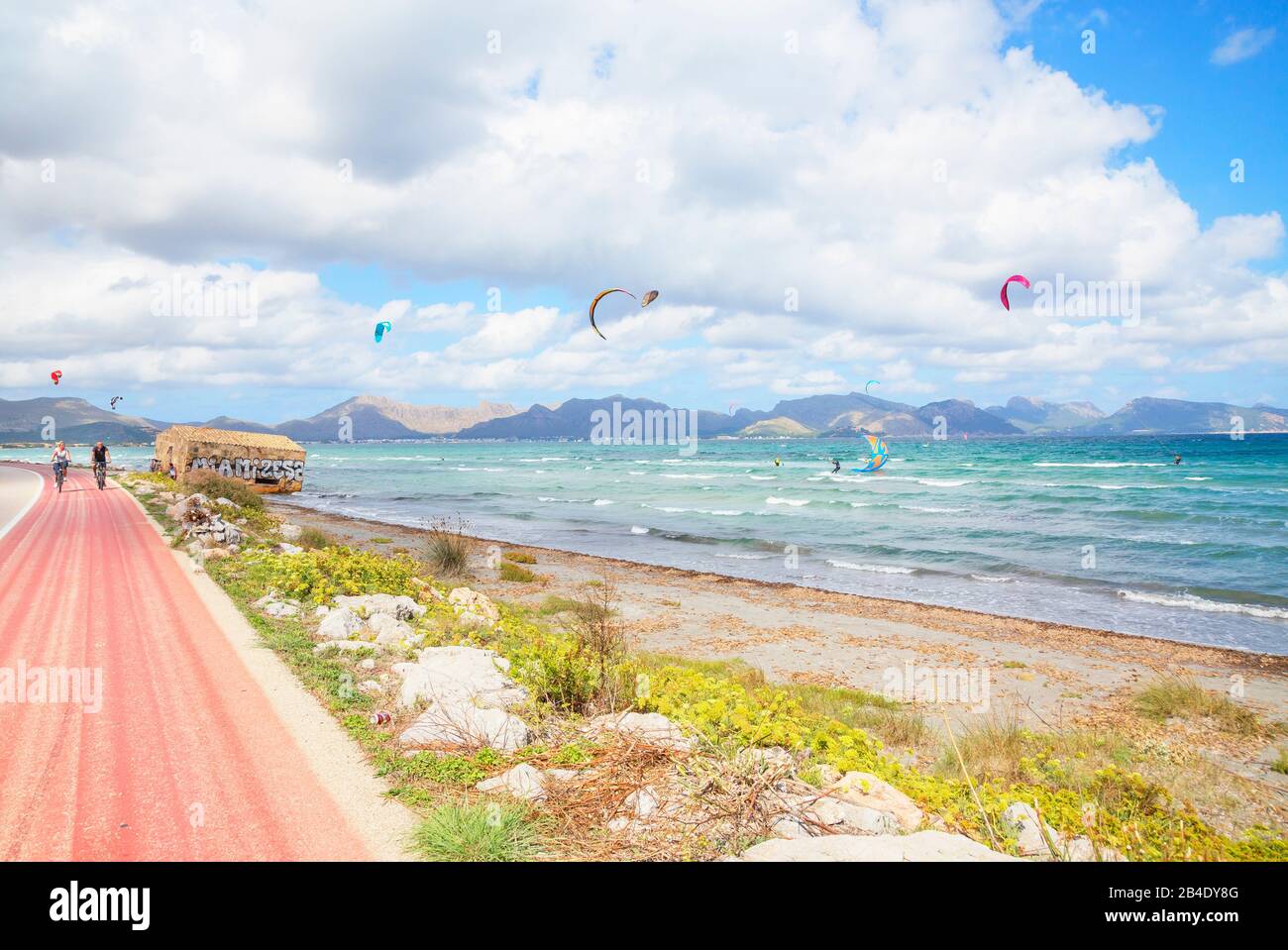 Coppia in bicicletta vicino alla spiaggia di Alcudia. Mallorca (Maiorca), Isole Baleari, Spagna, Europa Foto Stock