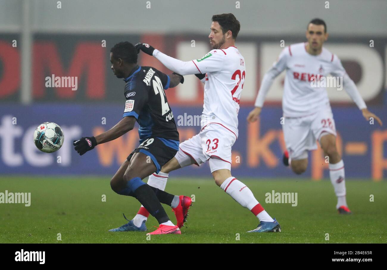 Paderborn, Germania. 06th Mar, 2020. Calcio: Bundesliga, SC Paderborn 07 - 1st FC Colonia, 25th matchday nella Benteler Arena. Jamilu Collins di Paderborn (l) lotta per la palla con Mark Uth (r) da Colonia. Credito: Friso Gentsch/dpa - NOTA IMPORTANTE: In conformità con le norme del DFL Deutsche Fußball Liga e del DFB Deutscher Fußball-Bund, è vietato sfruttare o sfruttare nello stadio e/o dal gioco fotografato sotto forma di immagini di sequenza e/o serie di foto video-simili./dpa/Alamy Live News Foto Stock