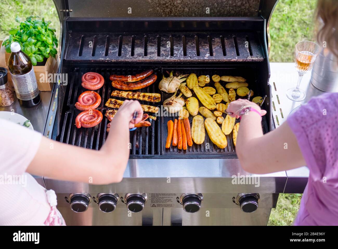 Due donne hanno un barbecue in giardino, barbecue Foto Stock