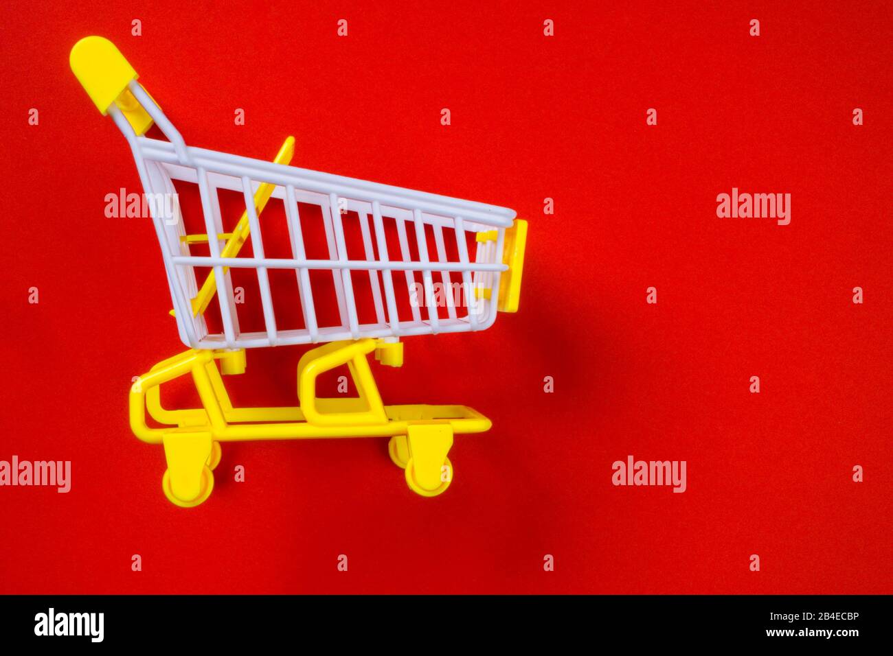 Shopping piccolo trolley su sfondo blu, Copy space. Vendita o acquisto di concetto di consumatore, sconti, foto minimalistica Foto Stock