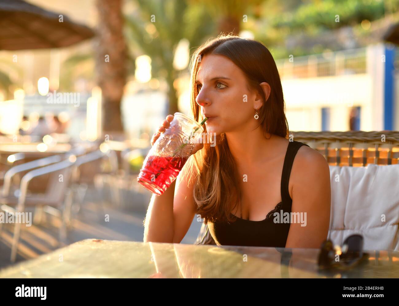 Giovane donna beve sangria in un bar sulla spiaggia, Calheta, Isola di Madeira, Portogallo Foto Stock