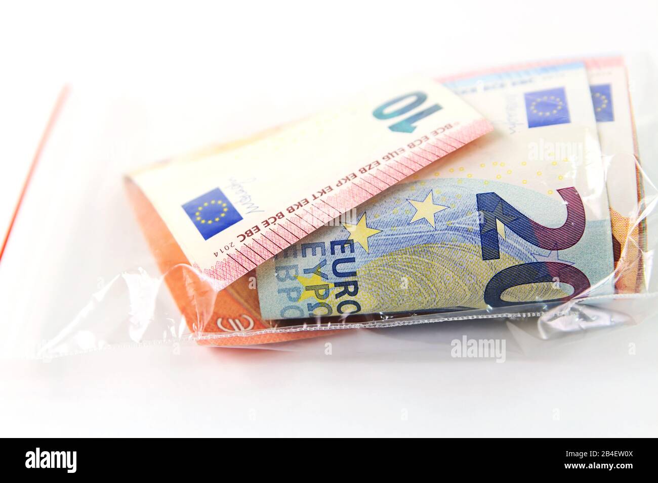Sacchetto di plastica trasparente con denaro che è una fonte di infezione Foto Stock
