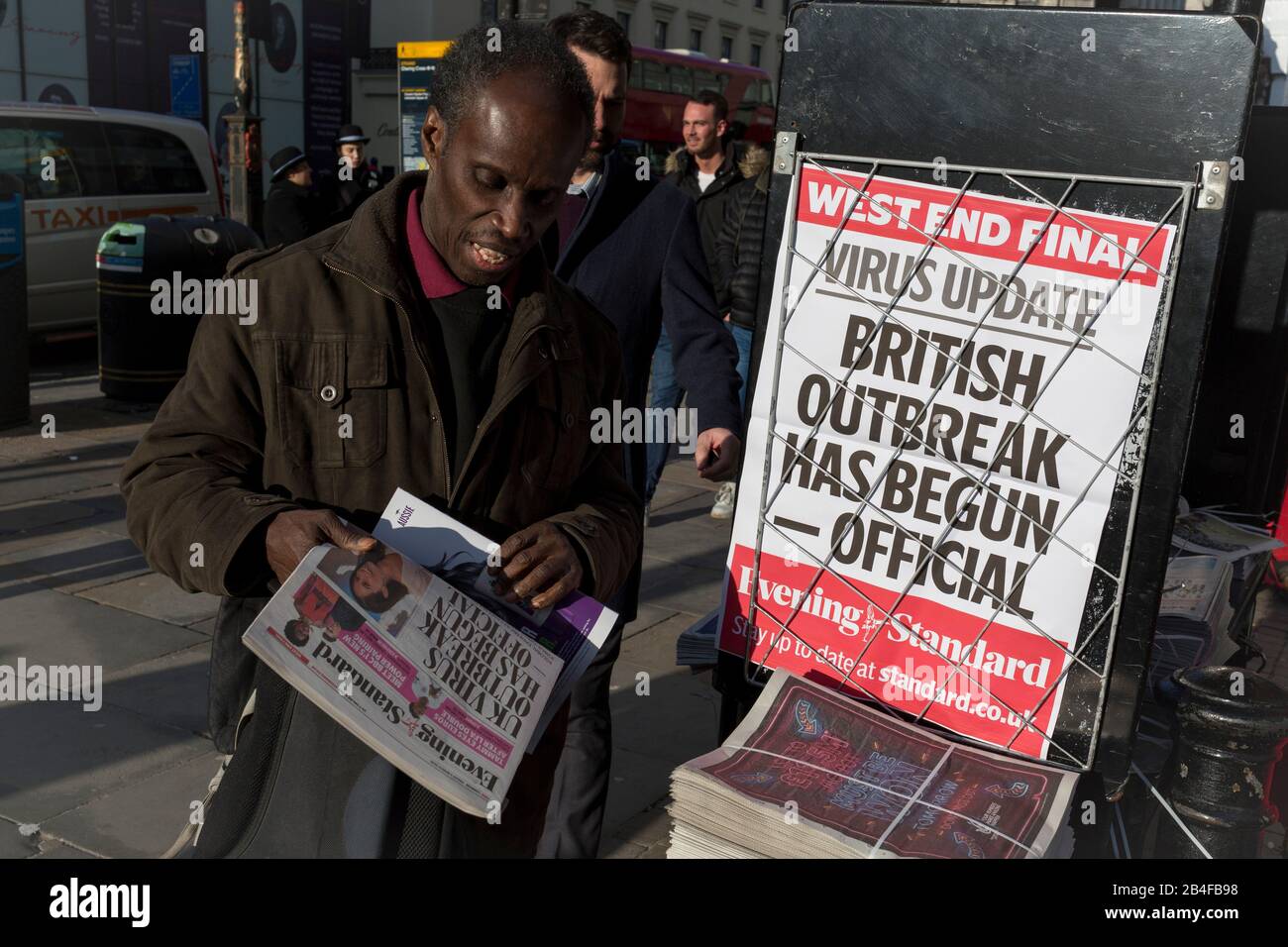 Il giorno in cui il Chief Scientific Advisor del governo britannico, Sir Patrick Vallance, ha affermato che lo scoppio del Coronavirus Covid-19 si stava diffondendo di persona nel Regno Unito, un londinese raccoglie copie del quotidiano London Evening Standard della capitale al di fuori della stazione ferroviaria di Charing Cross, il 6th marzo 2020, A Londra, Inghilterra. Foto Stock