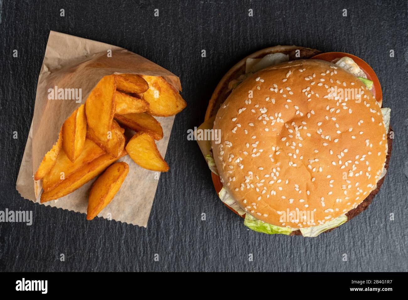 Patate In Carta Accanto Ad Un Hamburger Su Una Ardesia Piatti Di Pietra Nera Vista Dall Alto Primo Piano Foto Stock Alamy